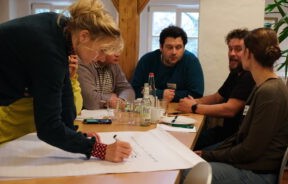 Frau schreibt Gruppenergebnisse auf bei Tagung.