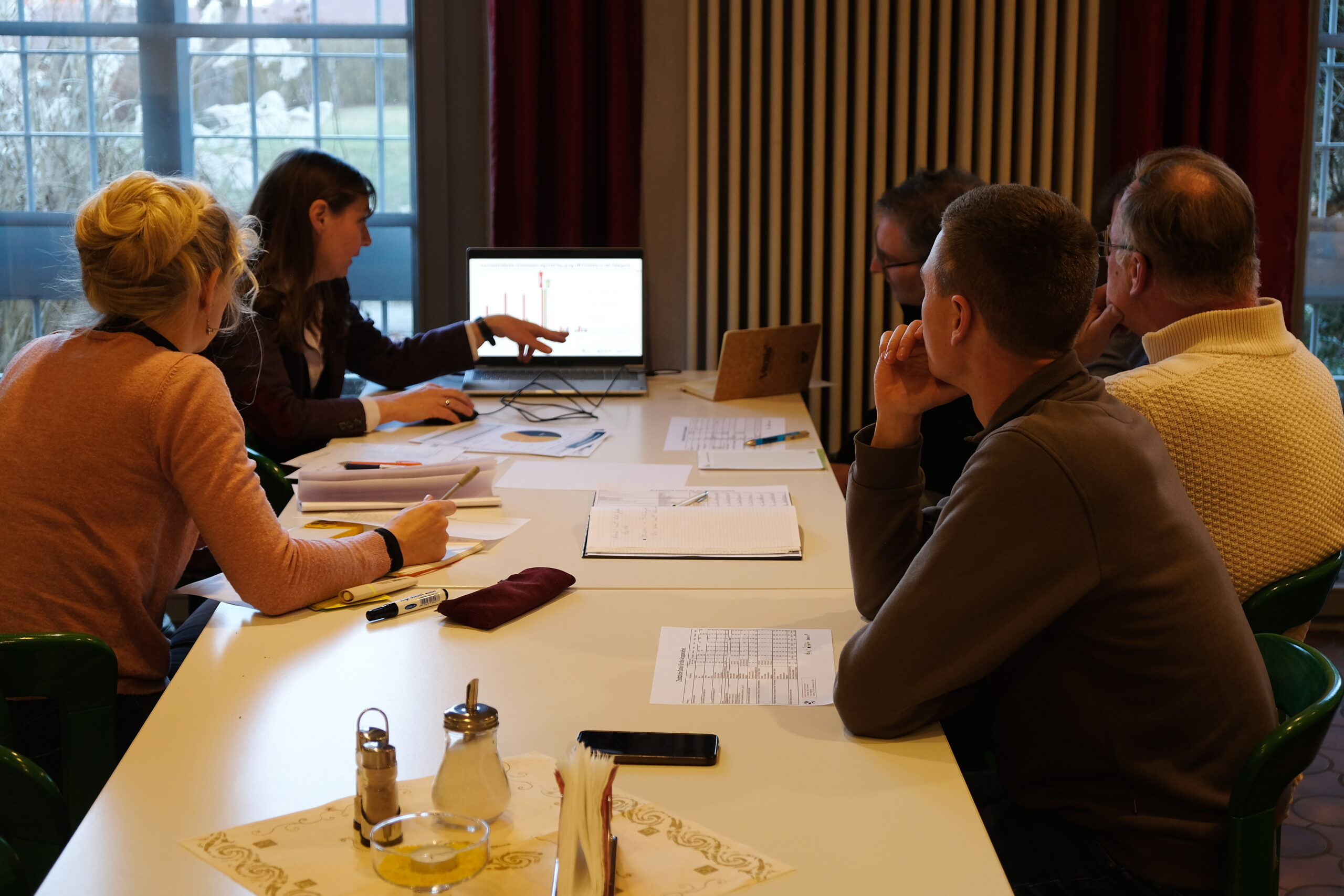 Gruppe diskutiert über Daten aus Laptop