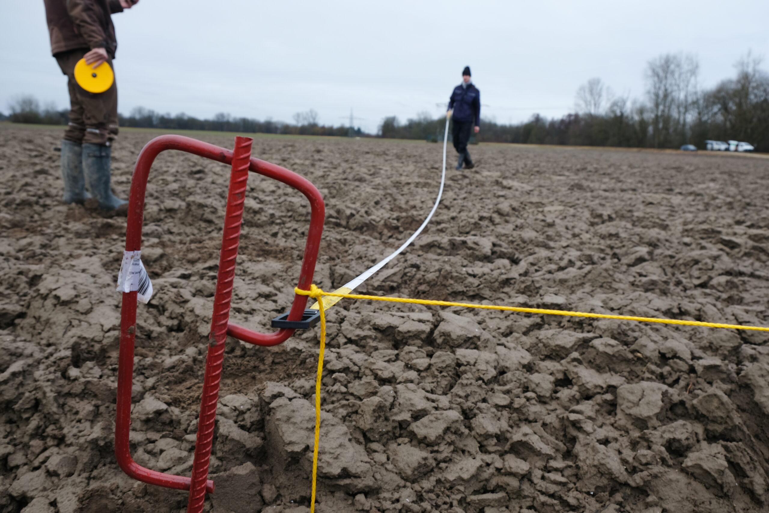 Personen vermessen Feldflächen für Probenahme und Versuche